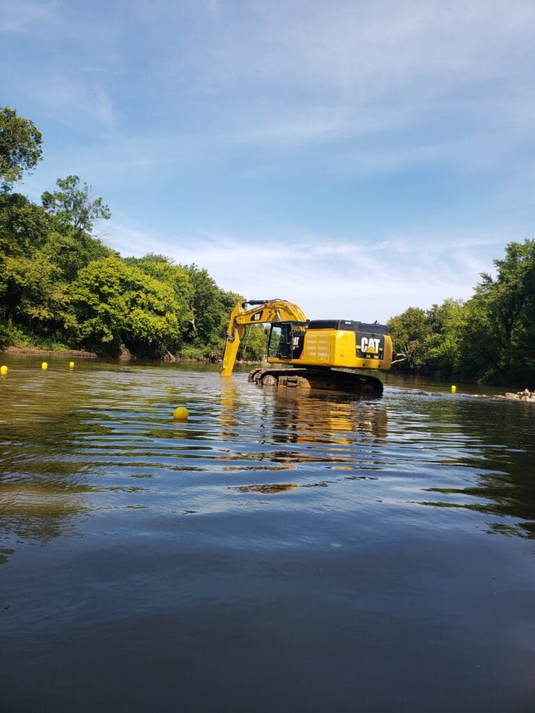 A truck excavating in the river.